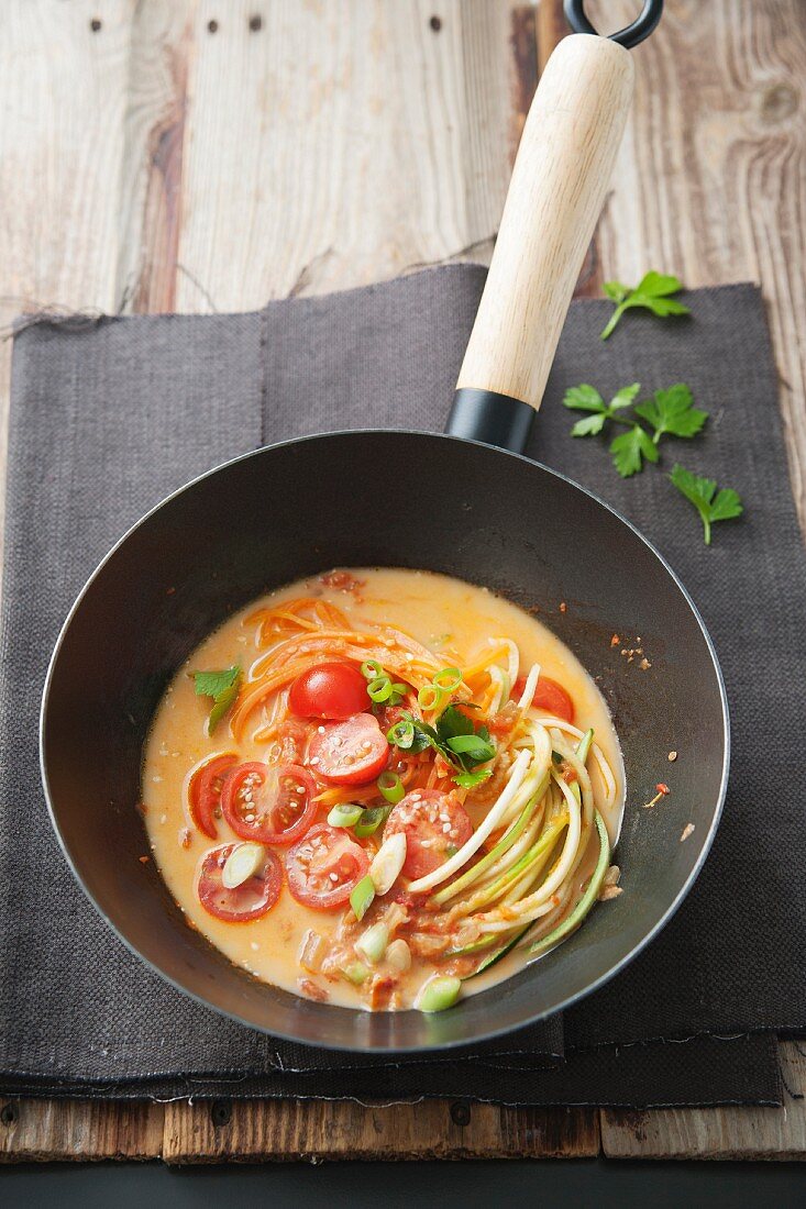 Vegetable Laksa: courgette spaghetti, carrots, spring onions, tomatoes and coriander in a spicy tomato and coconut sauce