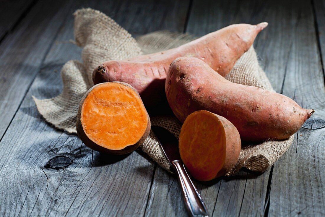 Sweet potatoes, whole and halved, on a sack