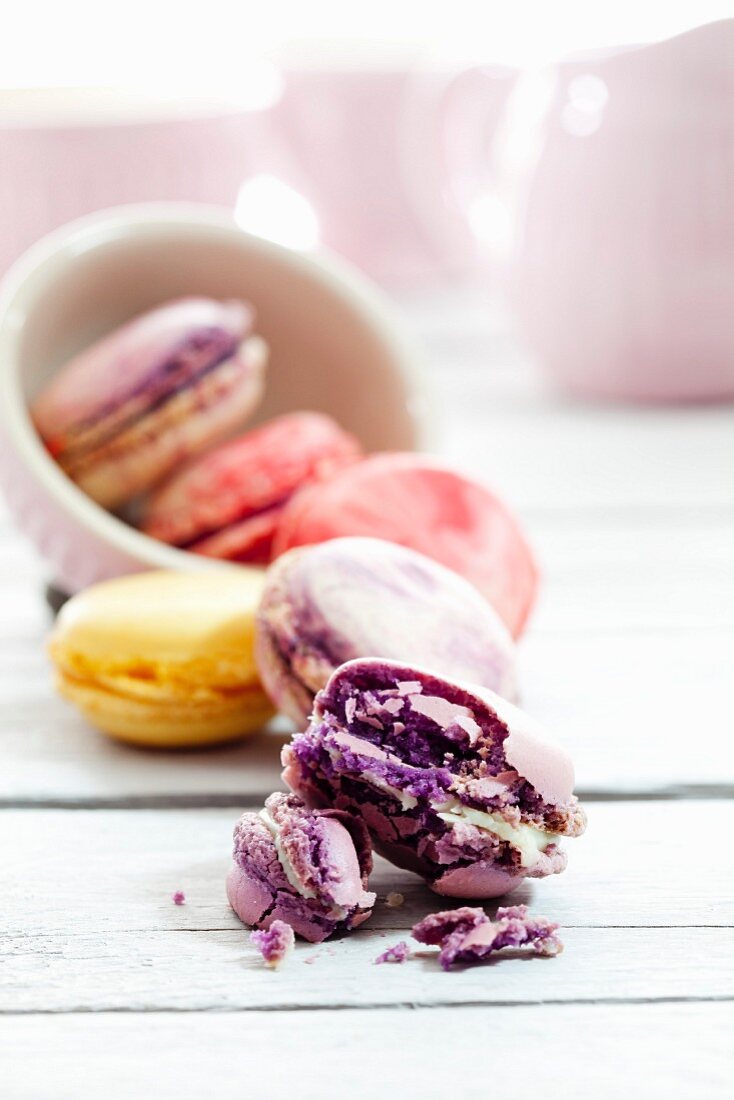 A bowl of colourful macaroons, one broken