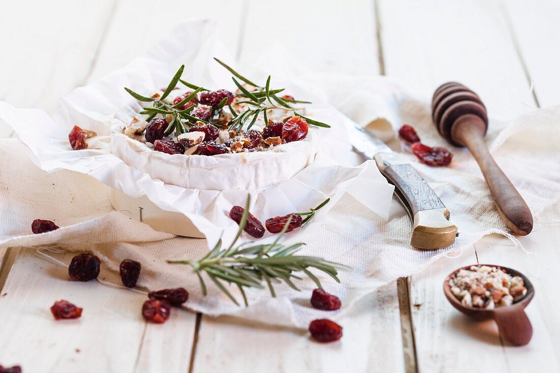 Baked Camembert with nuts, cranberries, rosemary and honey being made