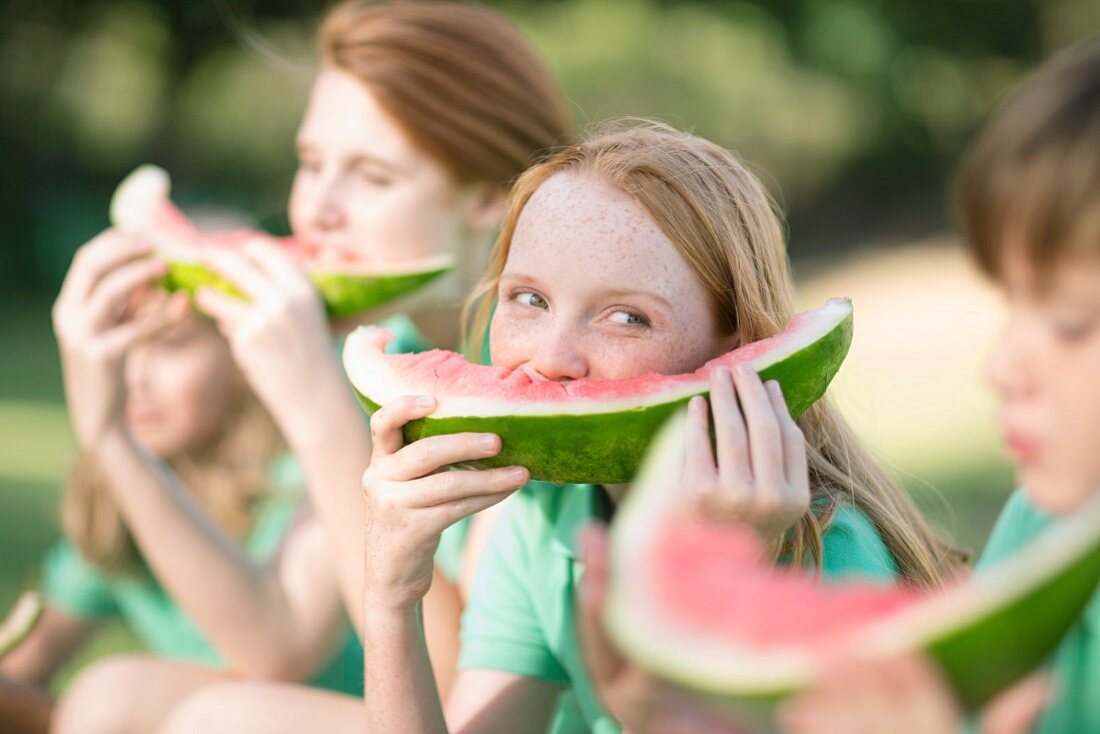 Children eating watermelon outside