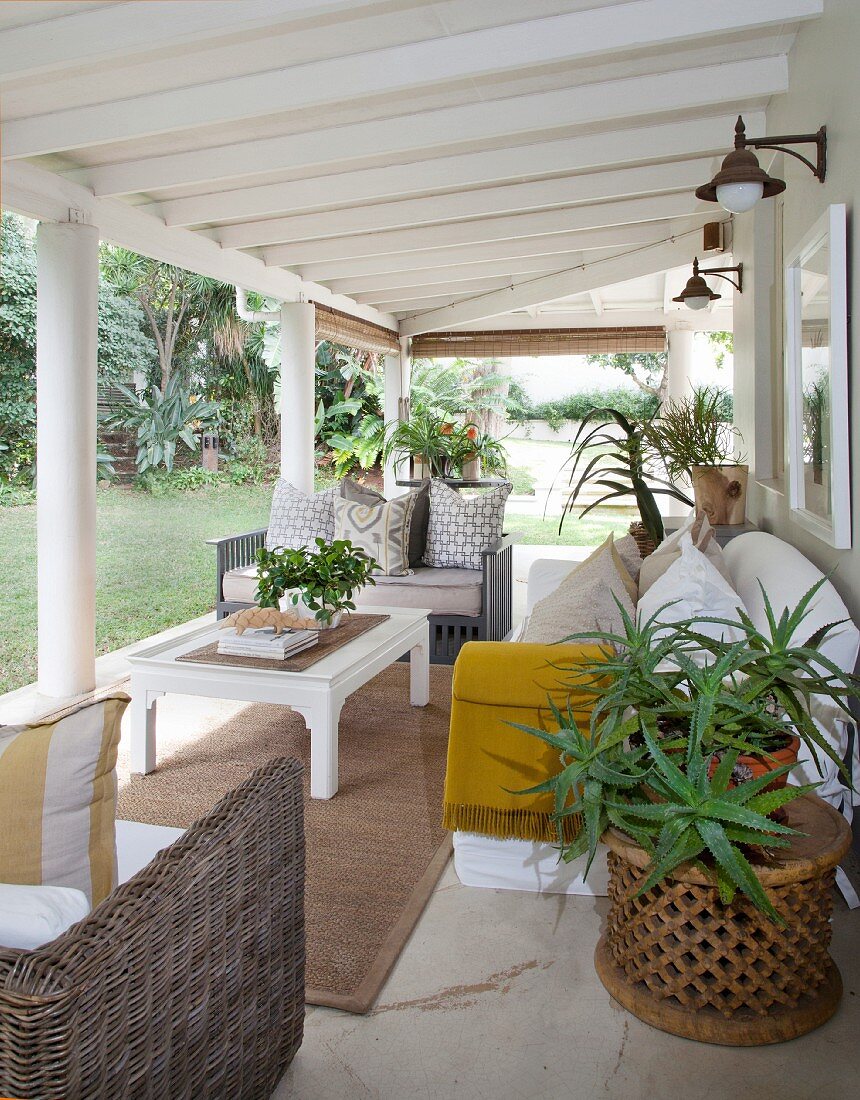 Überdachte Terrasse mit Couchtisch und Polstermöbeln