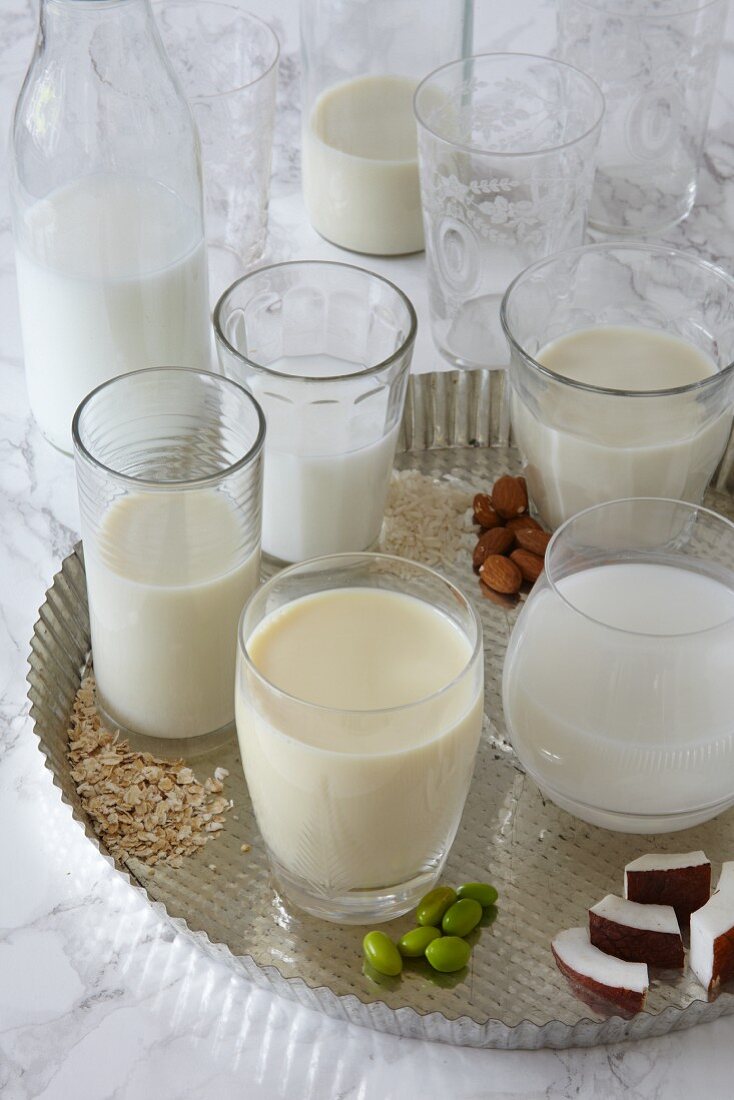 Various vegan milks in glasses on a tray