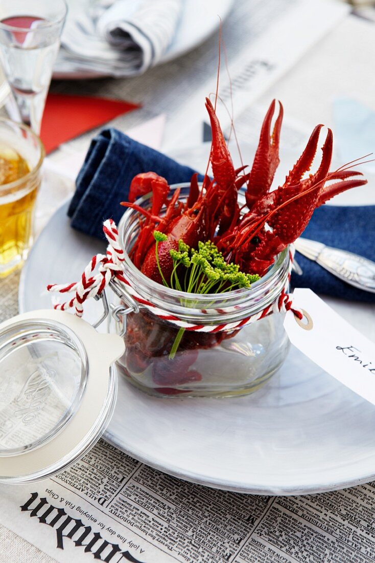 A place setting with cooked crayfish in a jar