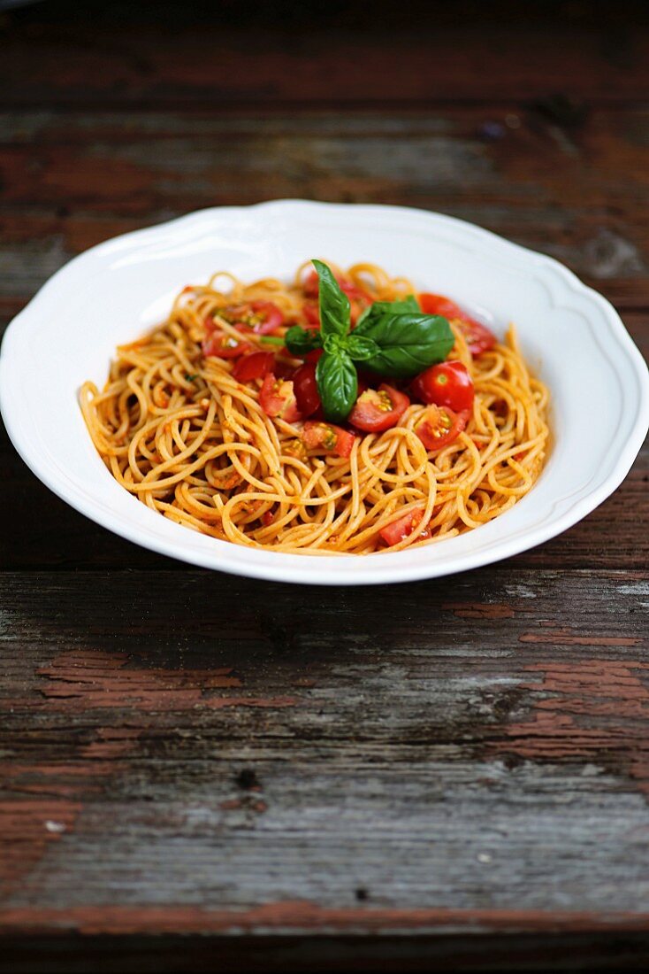 Spaghetti mit frischen Tomaten auf altem Holztisch