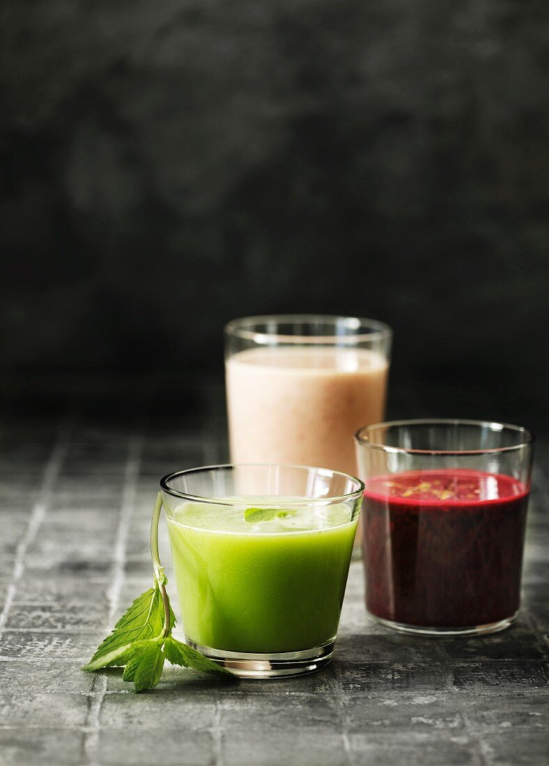 A green smoothie, a beetroot smoothie and a strawberry smoothie