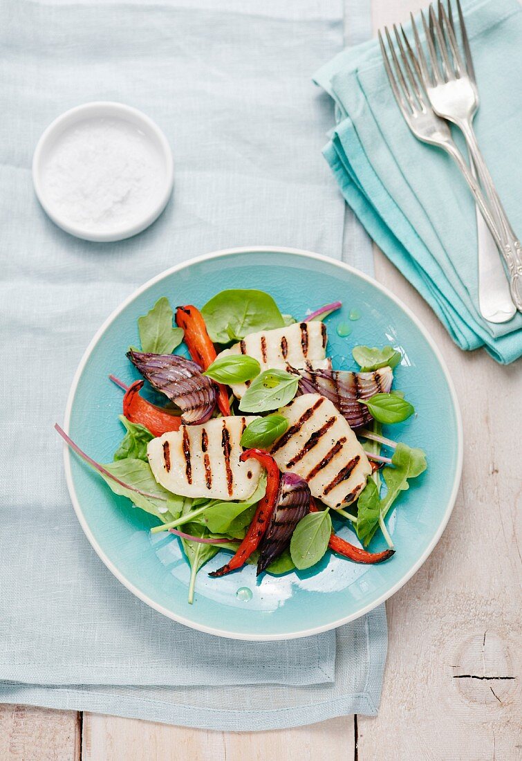 Grilled haloumi and onions on a bed of vegetables and lettuce