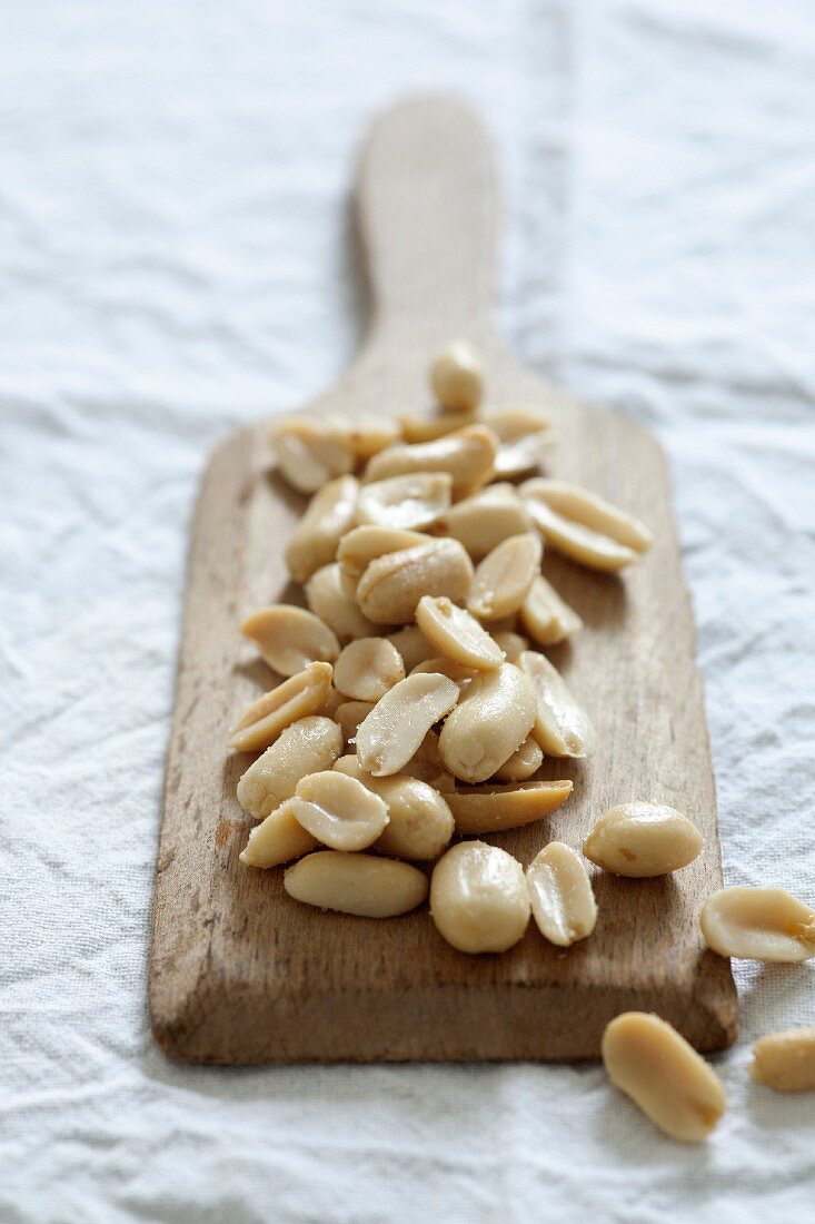 Salted peanuts on a small wooden board