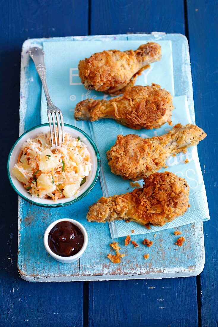 Fried chicken drumsticks with pineapple coleslaw and barbecue sauce