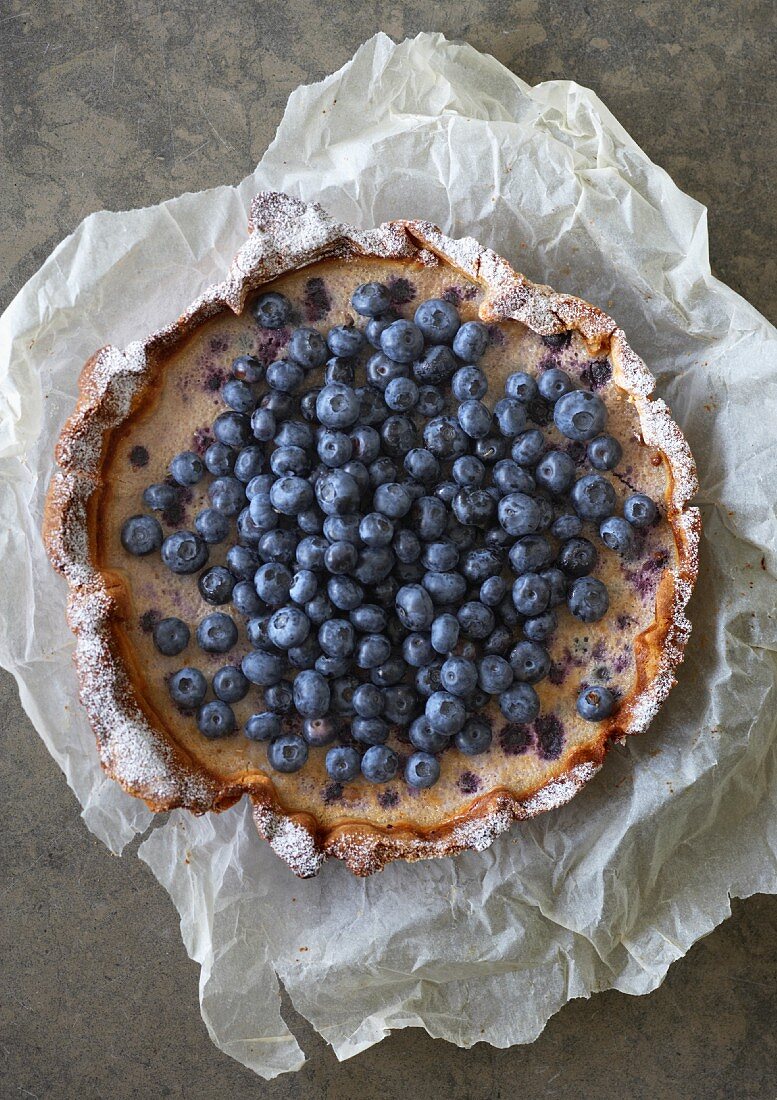 Blueberry tart on a piece of crumpled paper (seen from above)