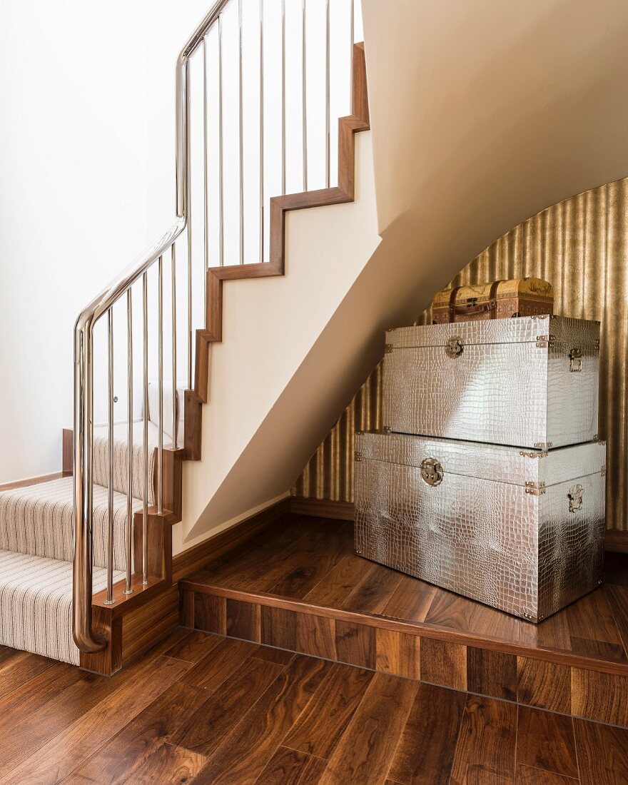 Embossed metal trunks below winding staircase