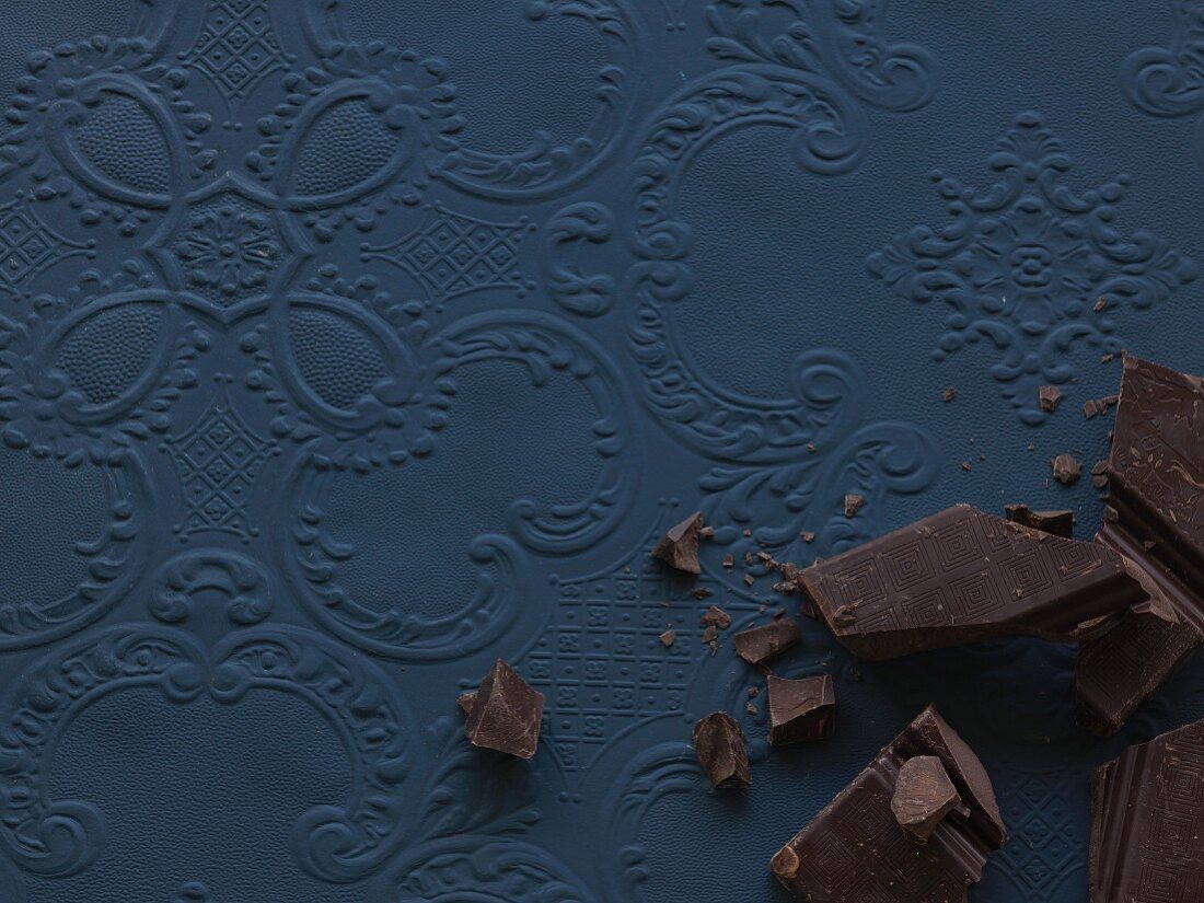 Pieces of chocolate on a blue surface