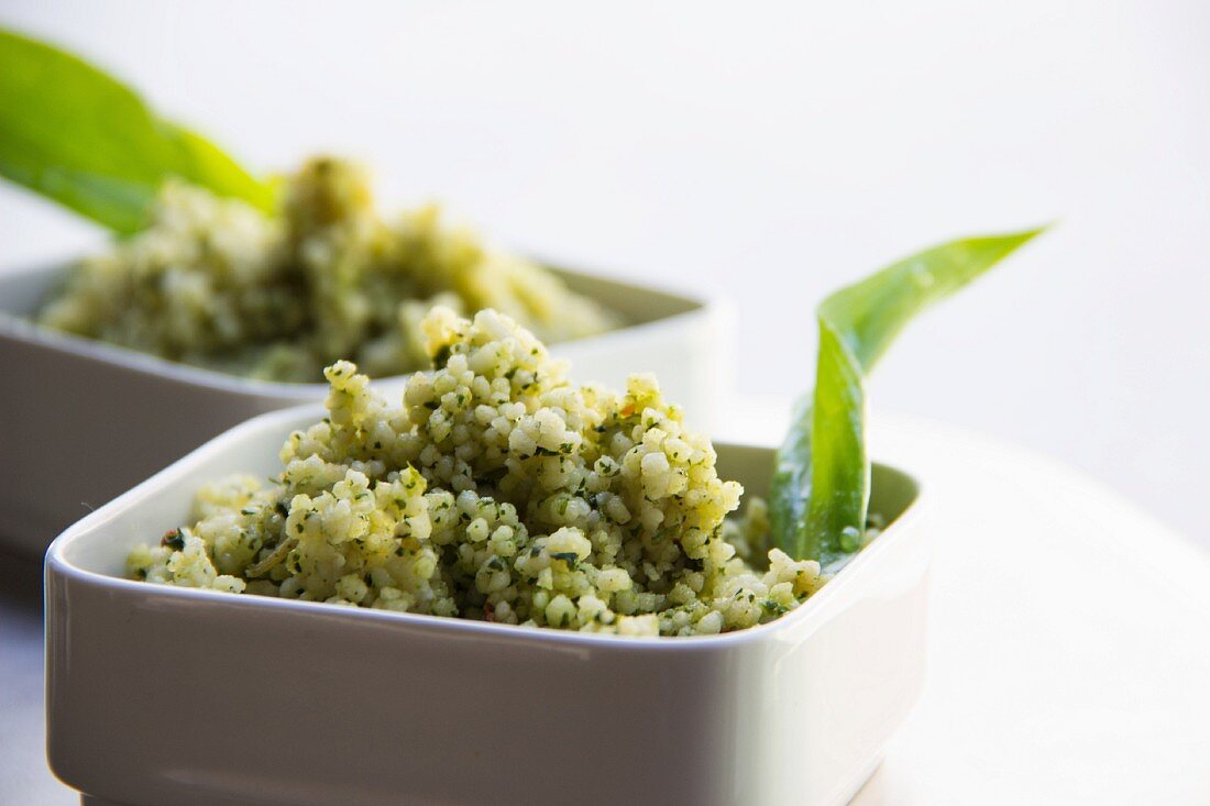 Weißes Quinoa als Salat mit Kräutern in weißem Schälchen