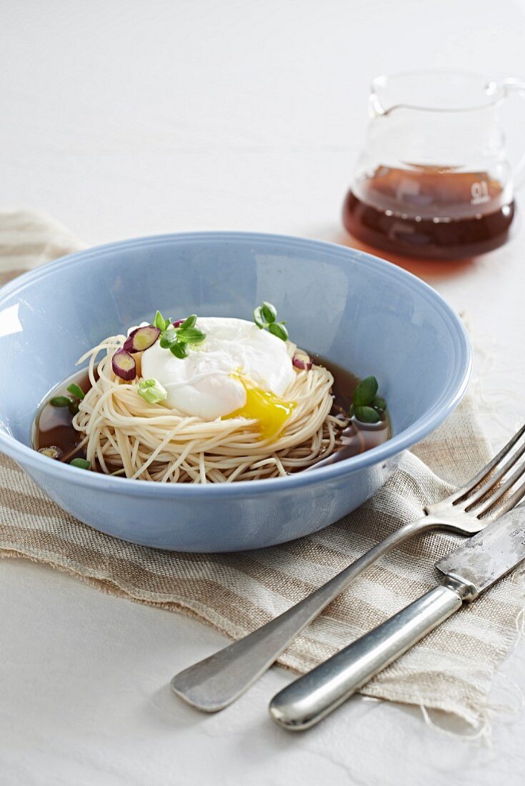Coffee and mushrooms soup with noodles and a poached egg