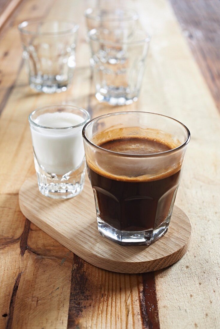 Kaffee im Glas und ein Schnapsglas voll Milch