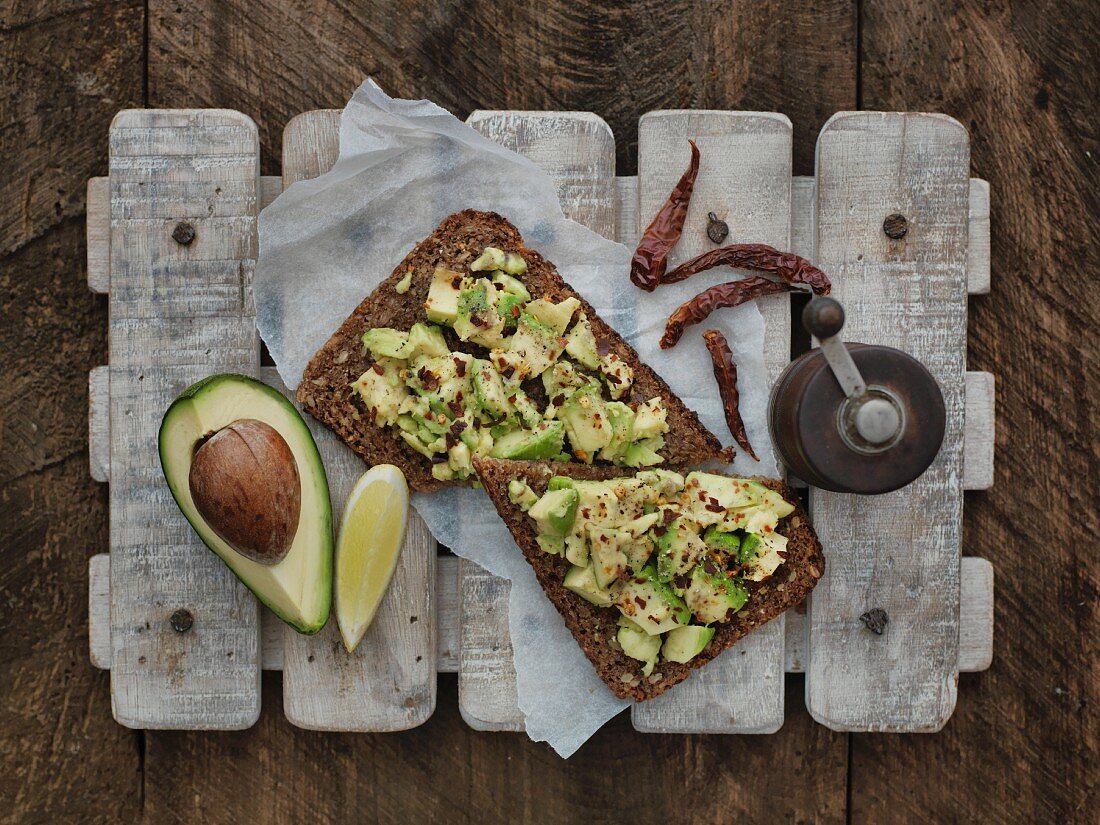 Slices of wholemeal bread with an avocado spread and chillis (seen from above)