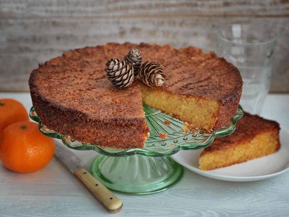 Orangenkuchen auf Kuchenständer, angeschnitten