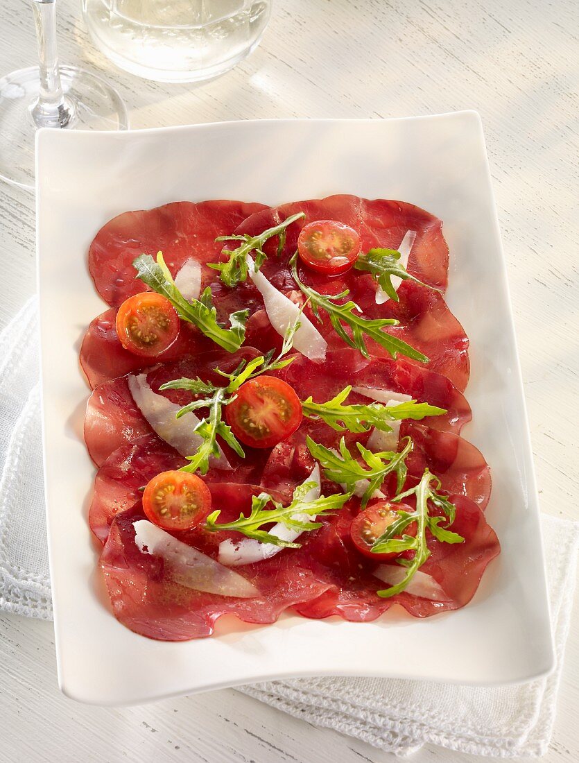 Beef carpaccio with cherry tomatoes, rocket and Parmesan cheese