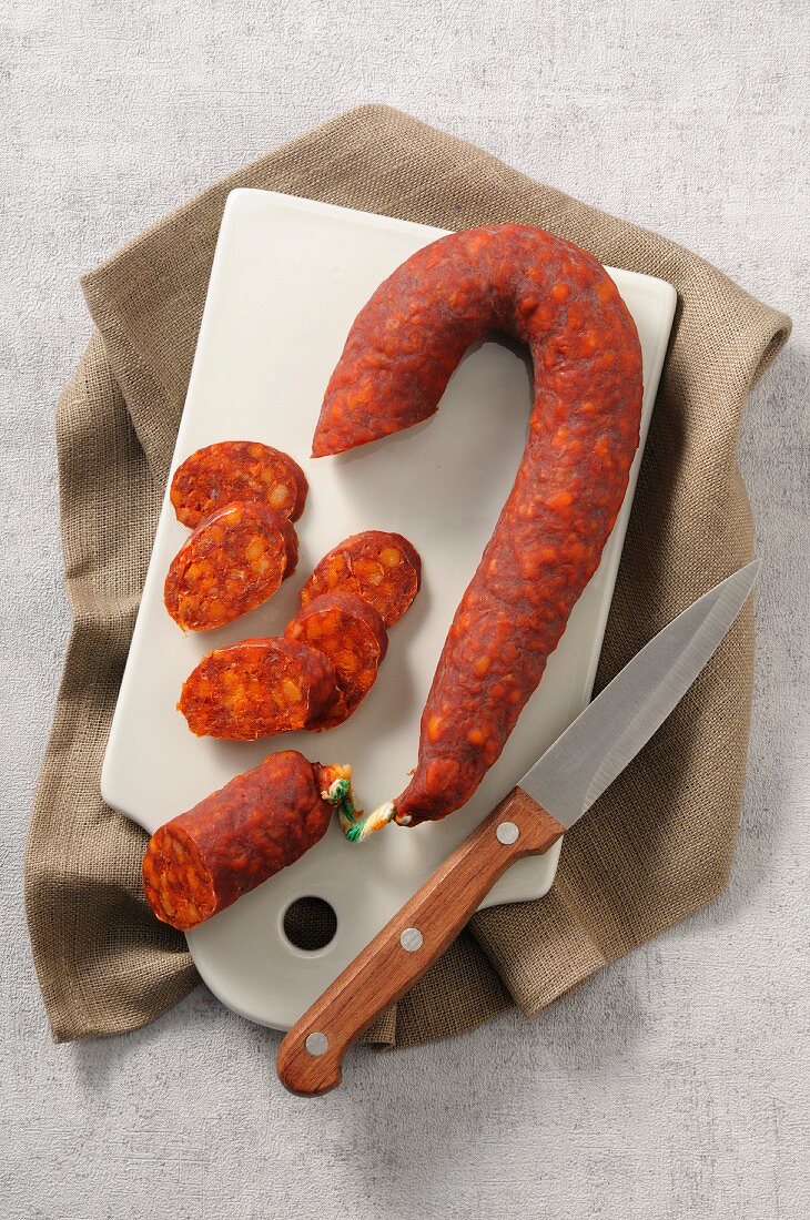 Chorizo (Paprikawurst, Spanien) mit Messer auf Schneidebrett
