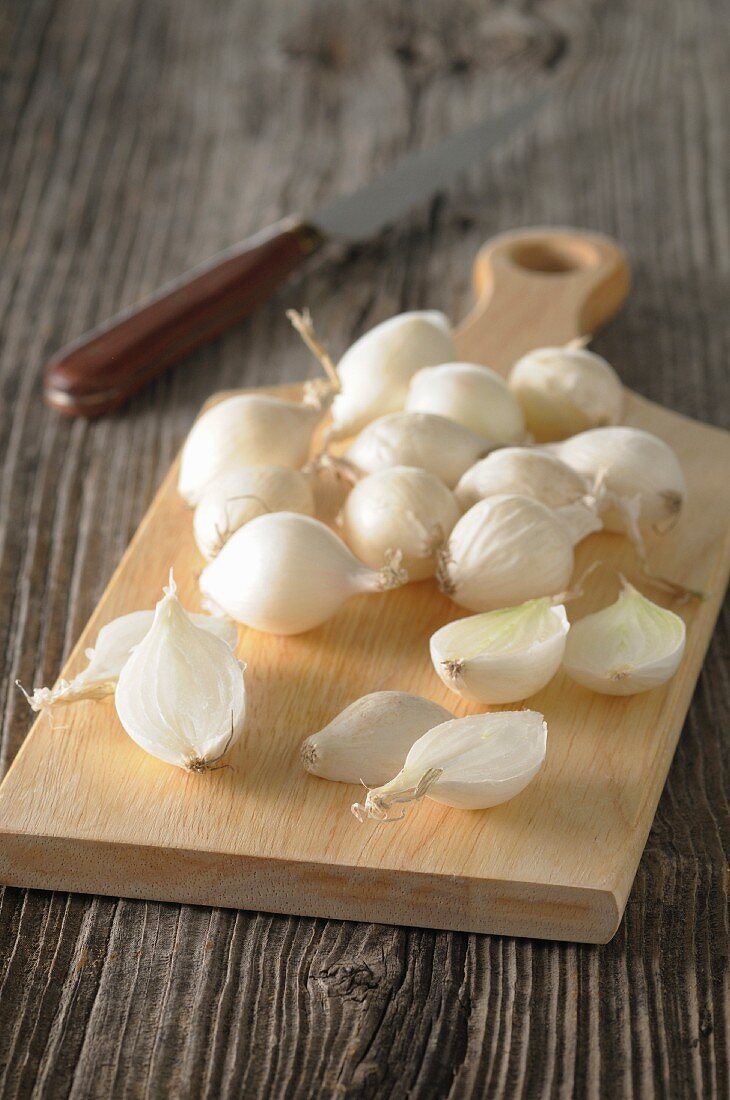 White onions on a wooden chopping board