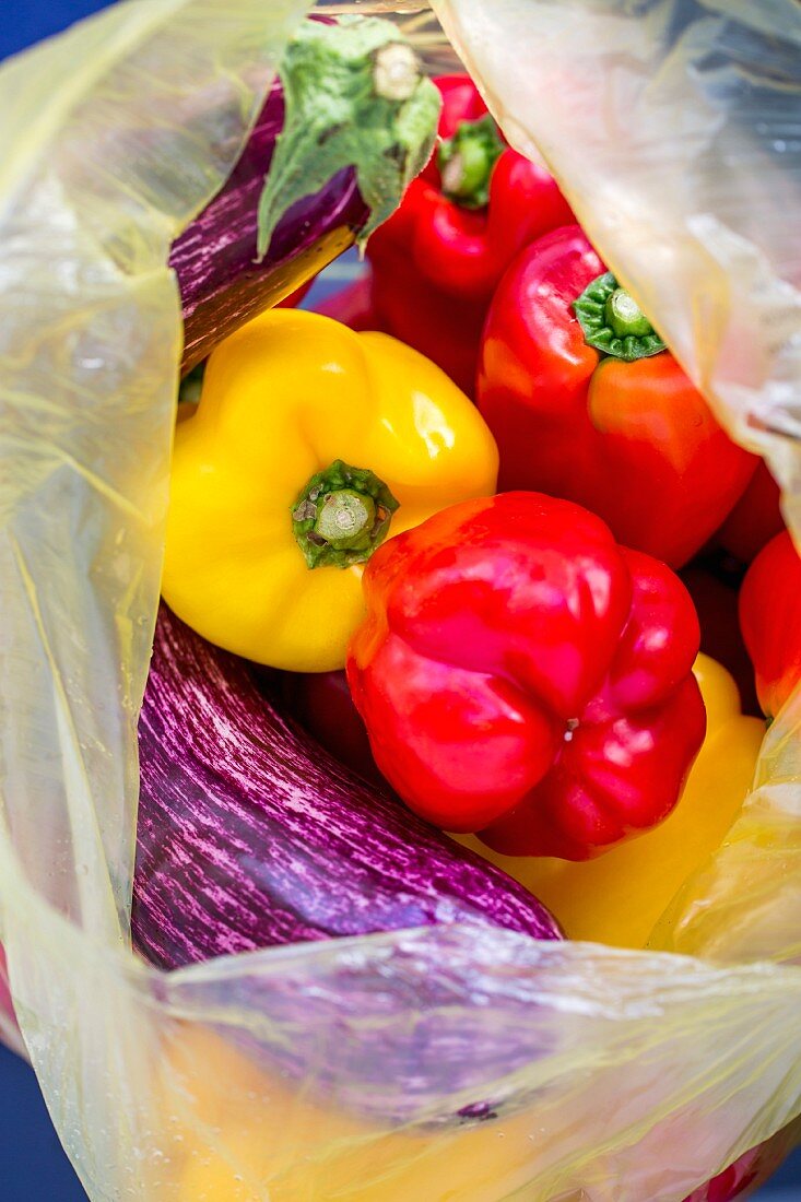 Fresh peppers and aubergines in a plastic bag
