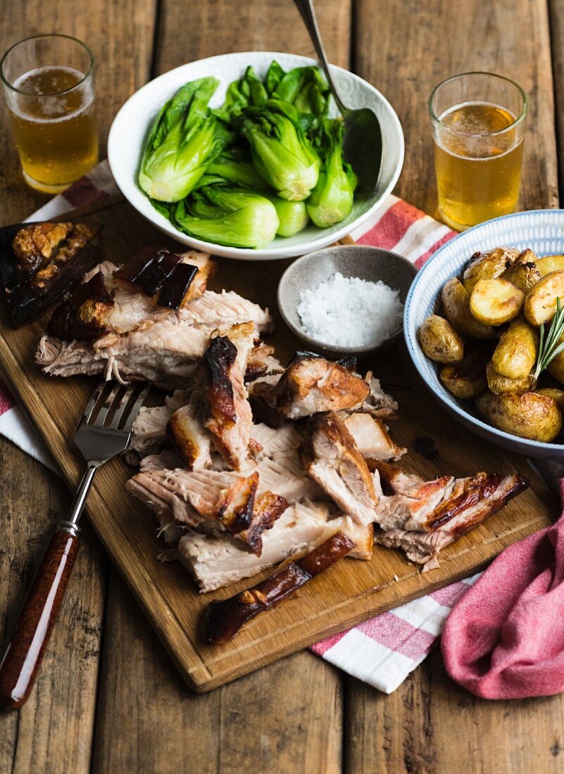Roast pork belly with rosemary potatoes, bok choy and beer
