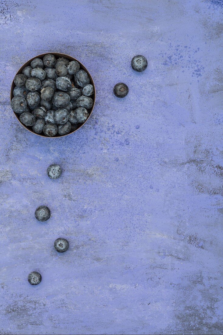 Blueberries in a bowl and next to it