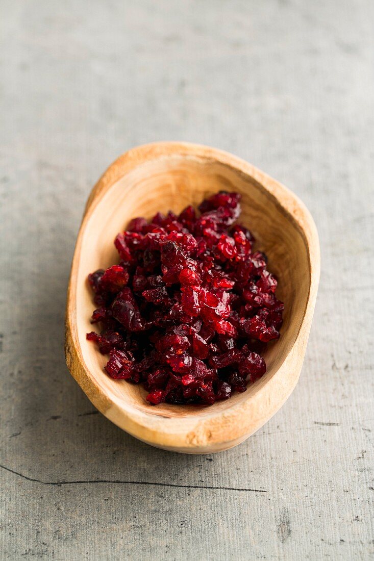 Chopped, dried cranberries in a wooden bowl
