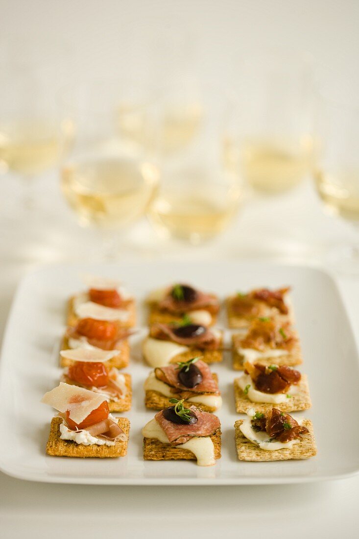 Crackers with various toppings served with white wine