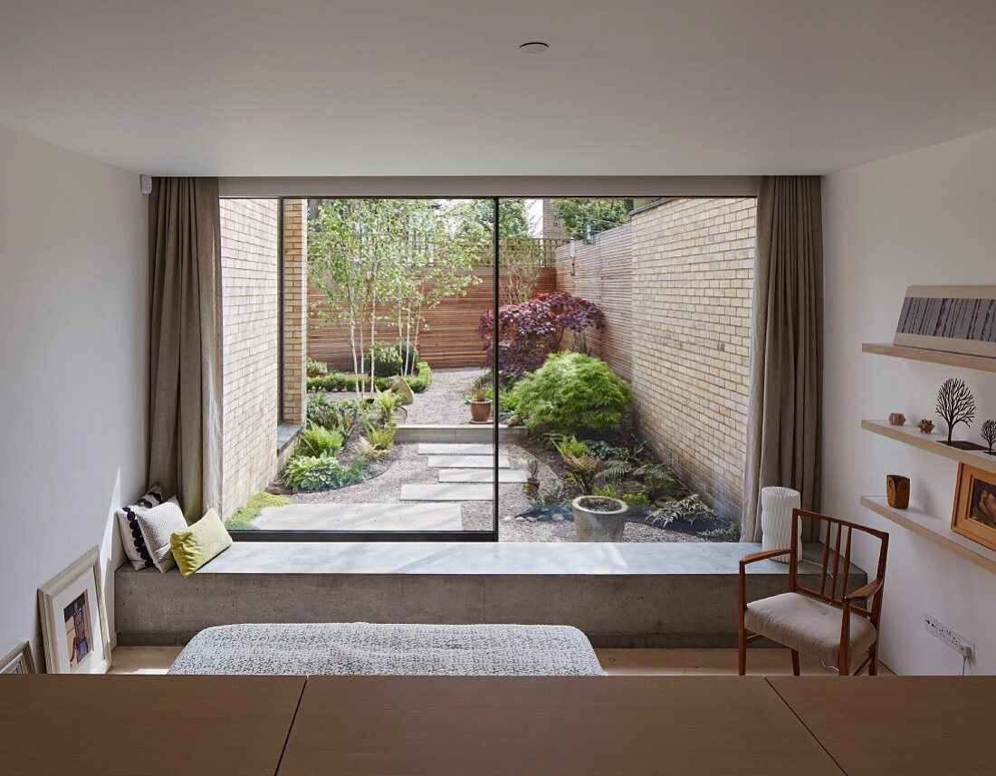 View from bedroom past concrete bench into courtyard