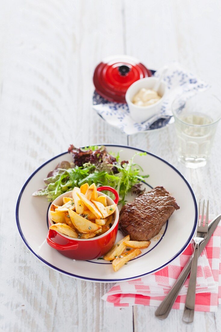 Beef steak with rosemary potatoes and frisee lettuce