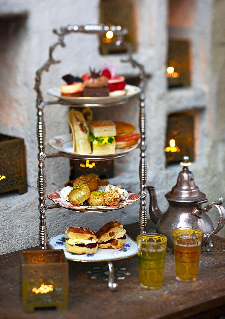 Sandwiches, scones and petit fours on a stand for teatime in a restaurant