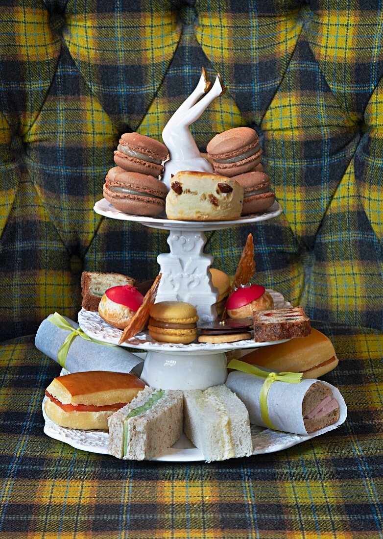 Sandwiches and macaroons on a vintage cake stand for teatime