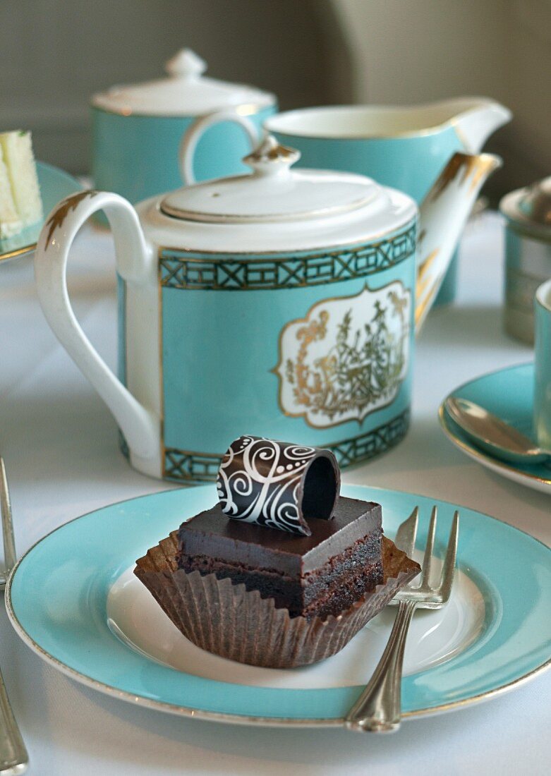 A petit four on a plate with turquoise tea crockery