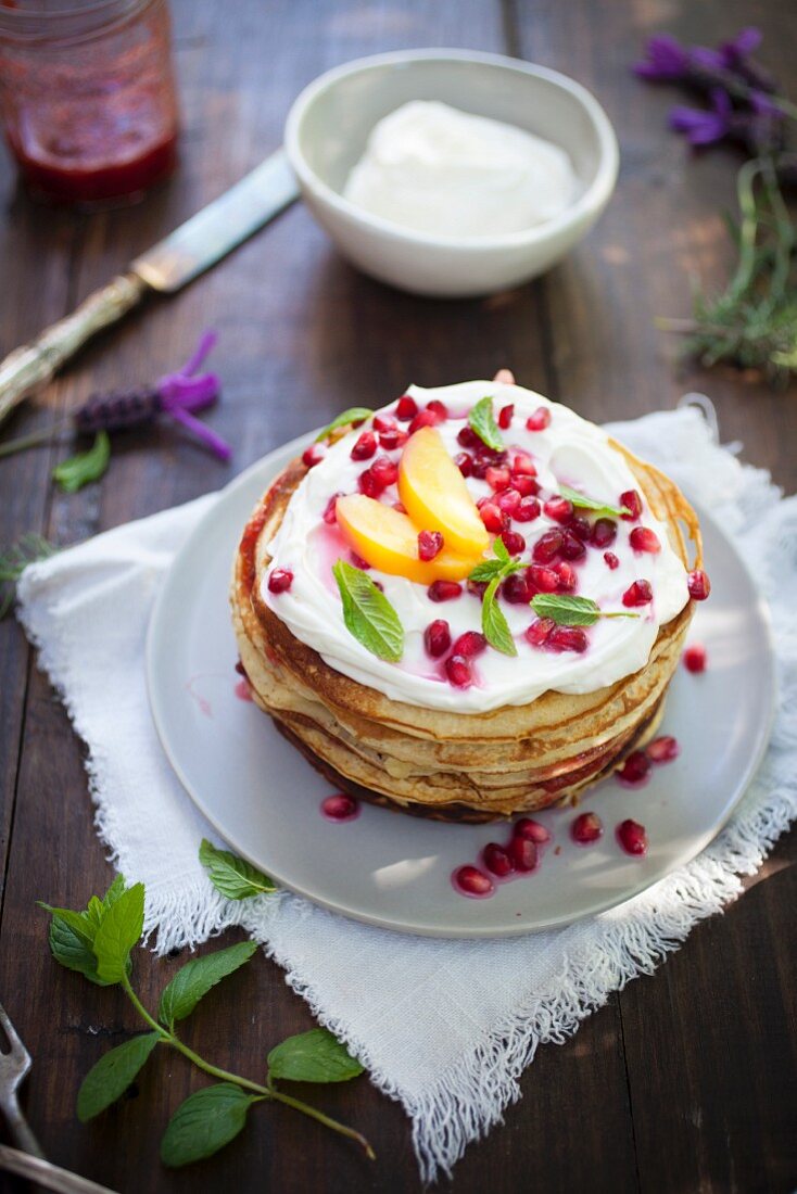 A pancake tower with ricotta and pomegranate seeds