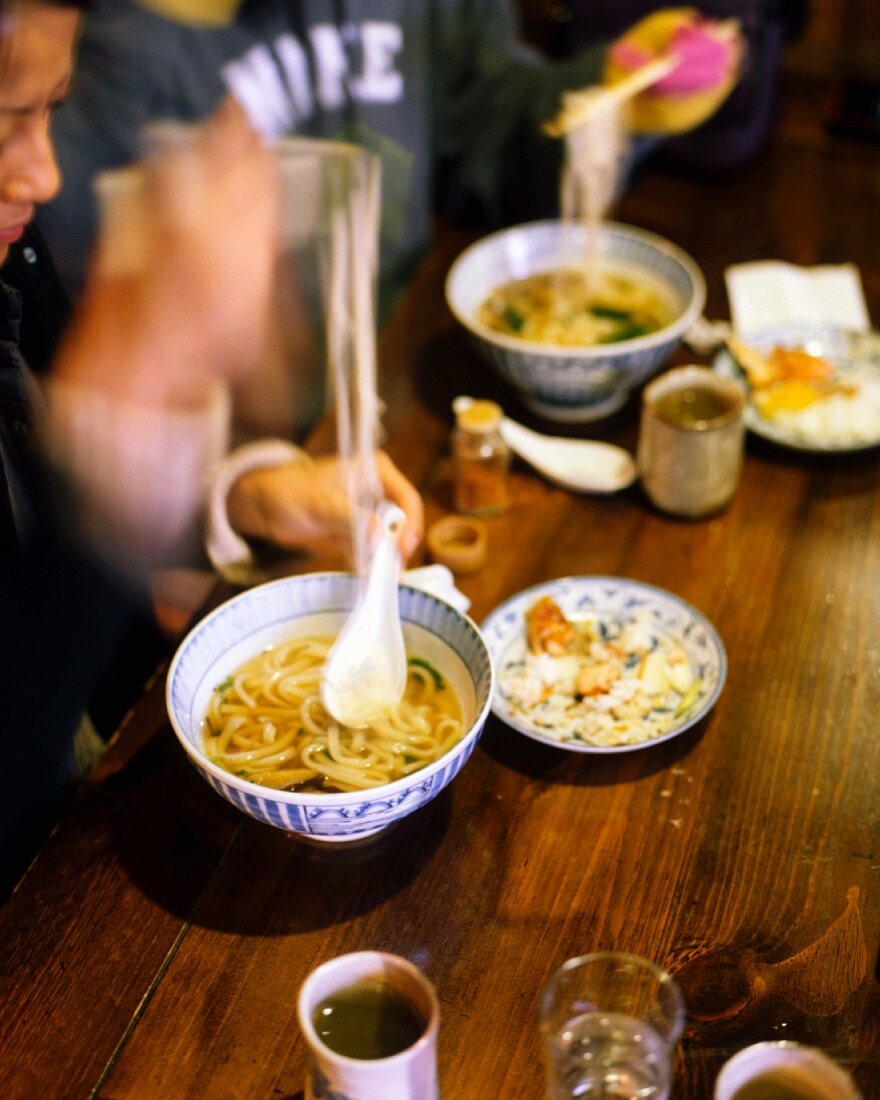 Guests eating noodle soup in a Japanese restaurant