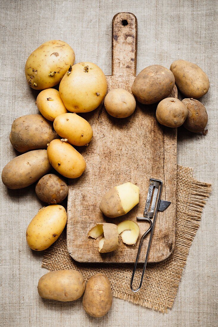 Potatoes with a chopping board and potato Peel