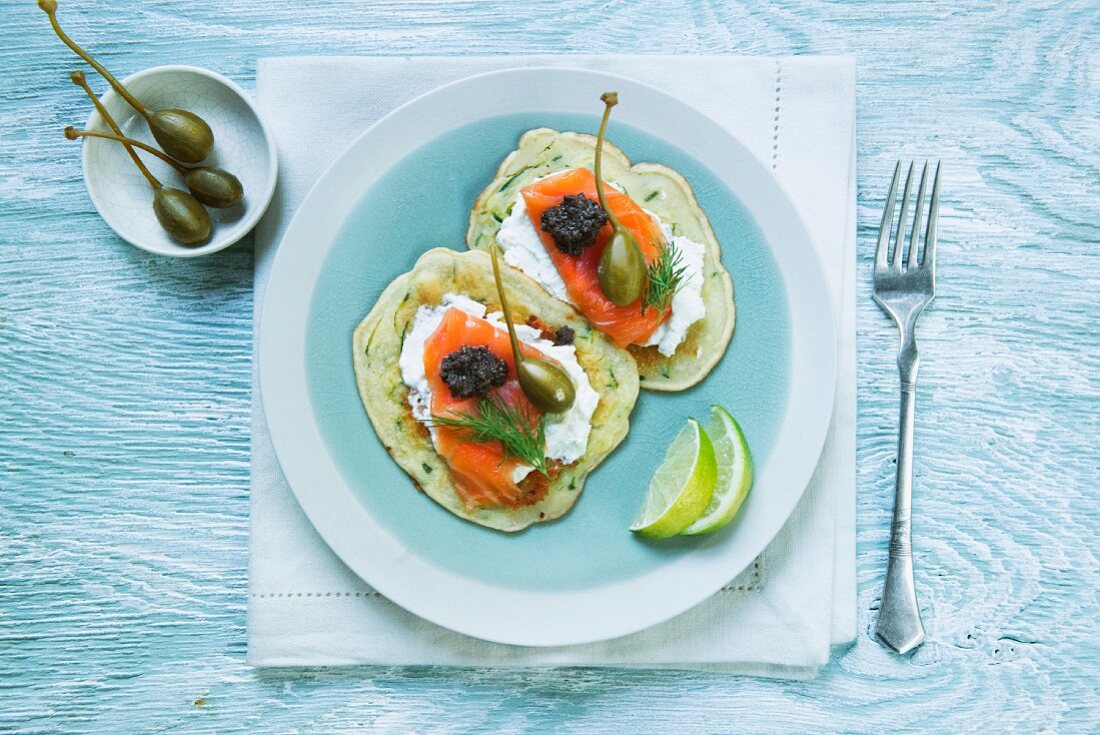 Courgette cakes with smoked salmon, crème fraîche, capers and tapenade