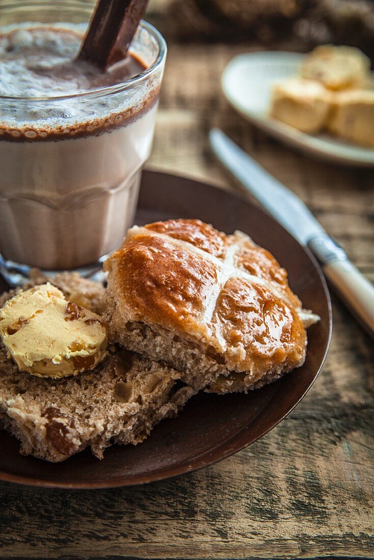 A hot cross bun served with cocoa