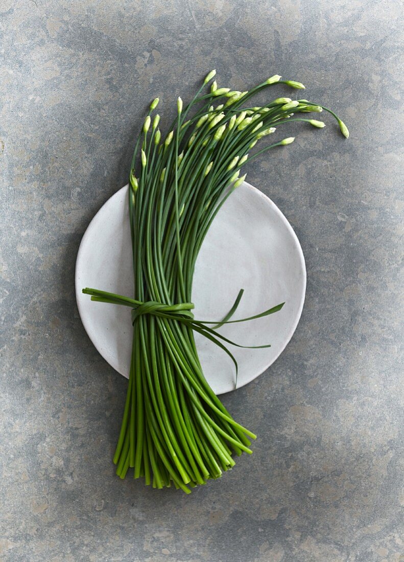 A bundle of garlic chives on a plate