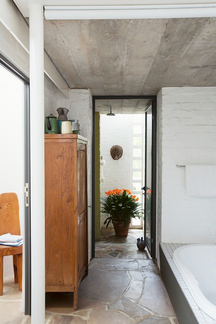 Bathroom with concrete ceiling, brick wall and stone floor