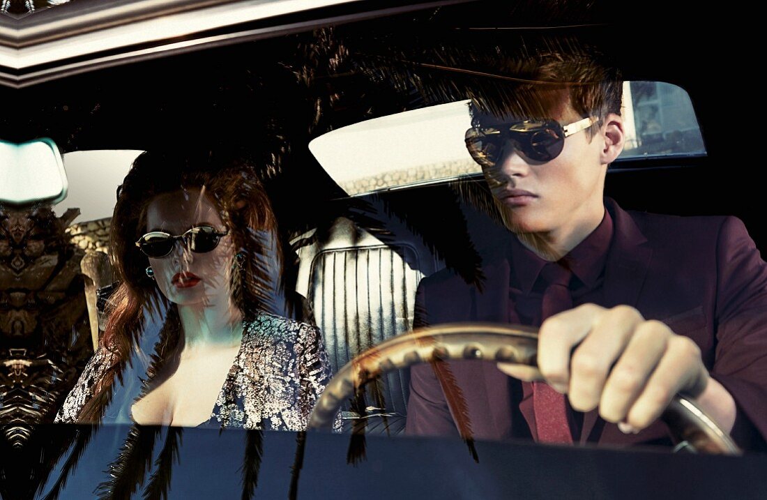 A young couple in a car wearing elegant clothing