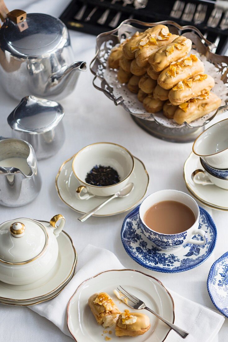 Caramelised white chocolate eclairs with almond milk cream and salted almond brittle served with tea