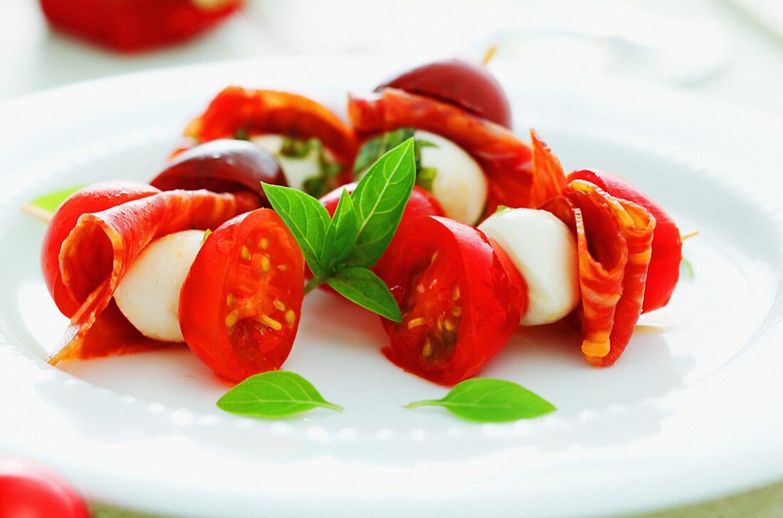 Tomatoes with mozzarella, salami and basil
