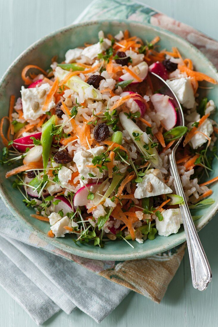 Rice salad with vegetables, feta cheese and raisins