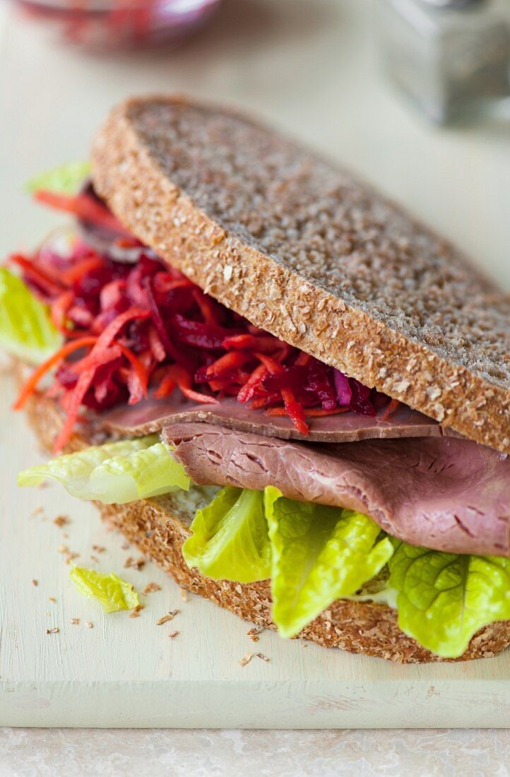 A roast beef sandwich, coleslaw and lettuce