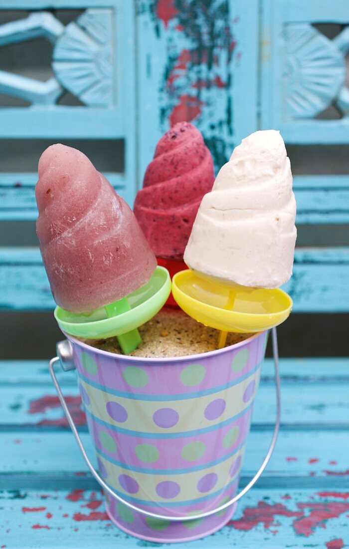 Three different homemade ice lollies in a bucket