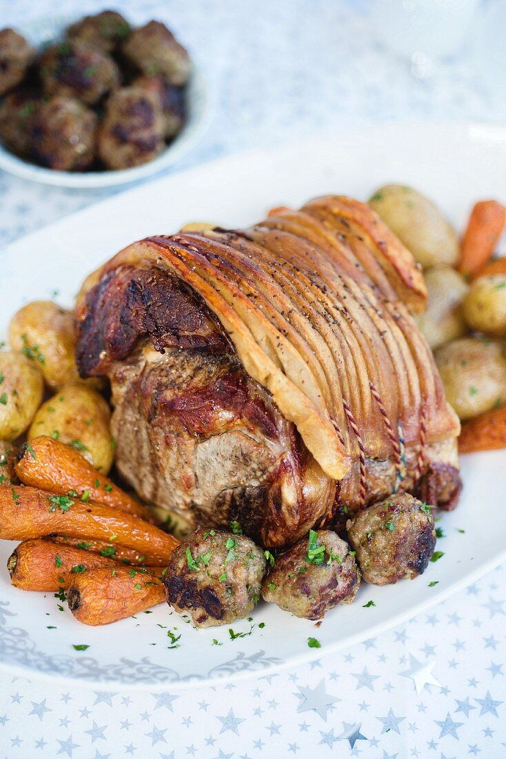 Schweinebraten mit Wurstklösschen und gebratenem Gemüse