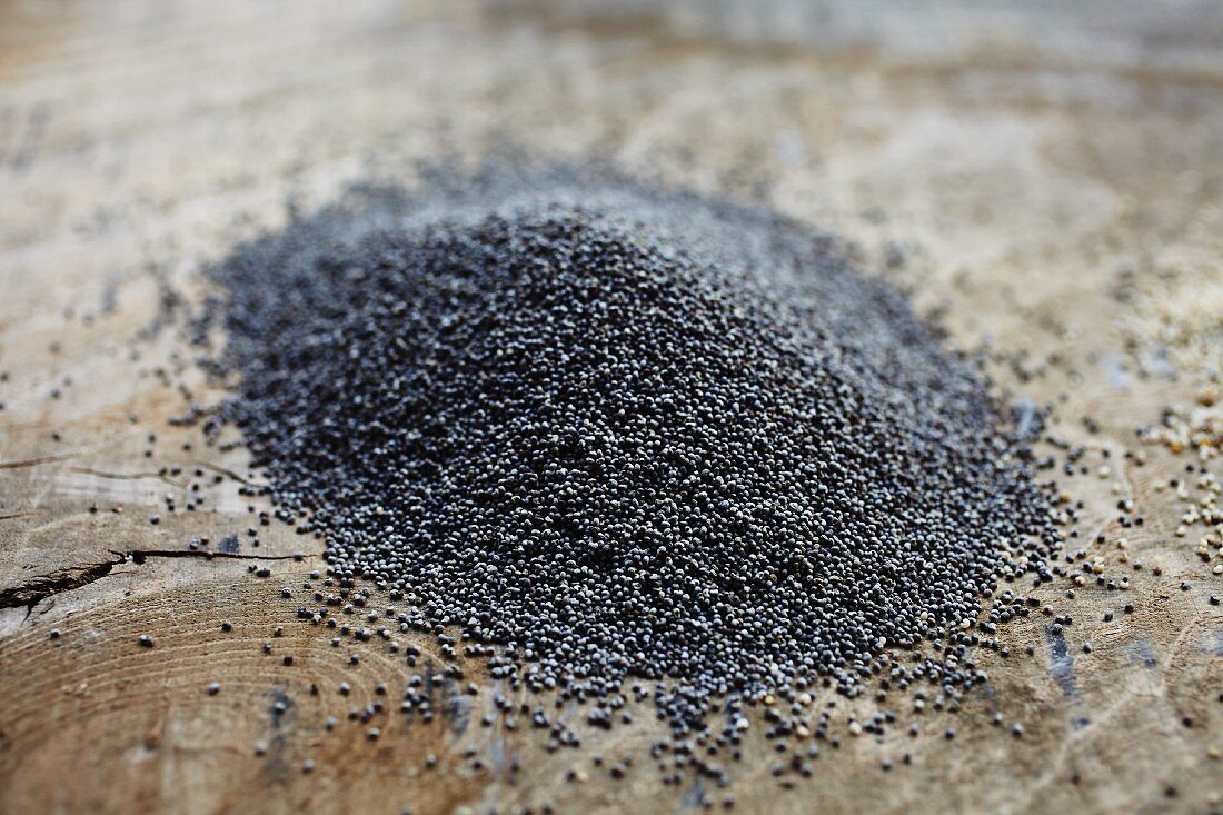 A pile of poppy seeds on a wooden board