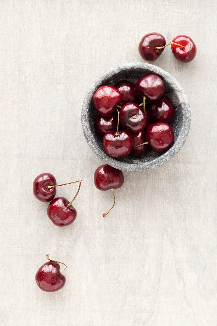 Fresh cherries in a marbled bowl and next to it